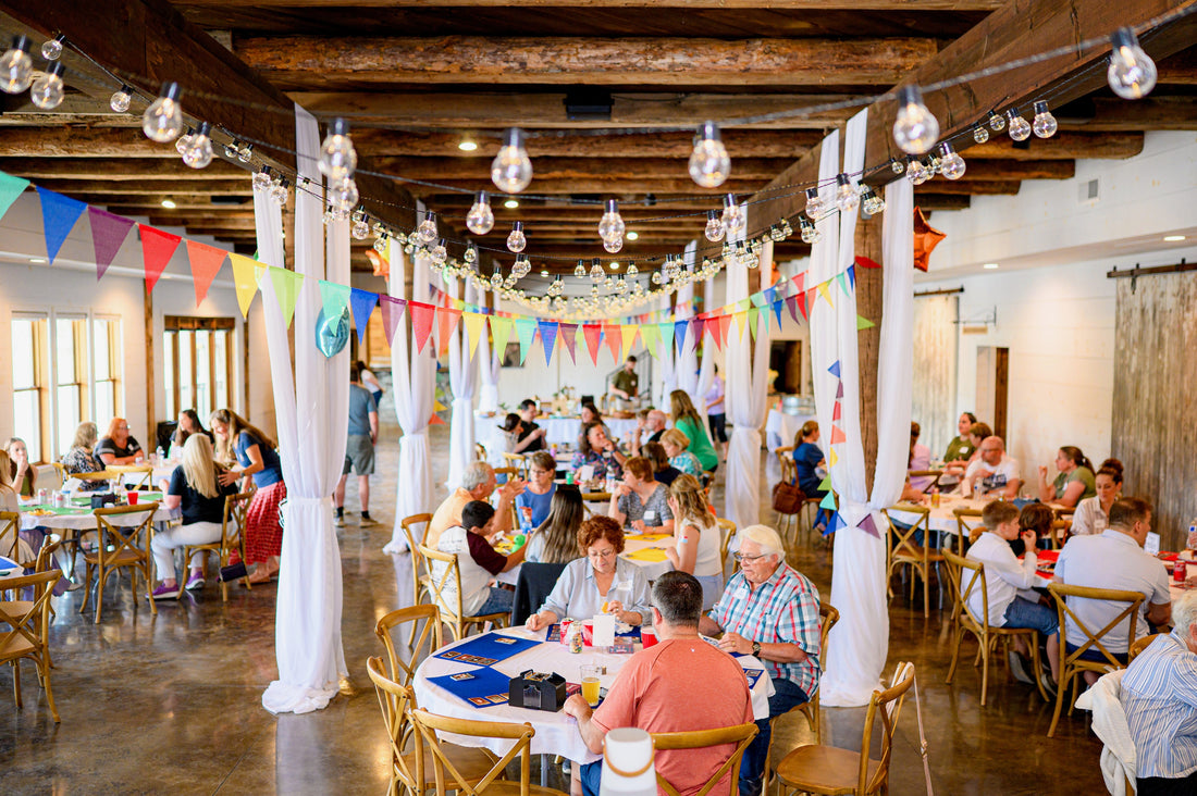 People gathered in a rustic finished barn setting playing our new card game.